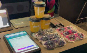 Óculos e copos personalizados da Agência HIRO distribuídos como ativação de marca durante o CMO Summit 2026.